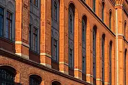 De hautes fenêtres mises en relief par l'éclairage du Soleil.