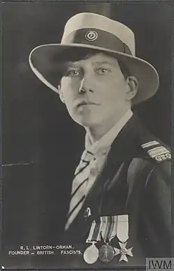 Photographie d'une femme de profil avec les cheveux courts en uniforme portant un chapeau et trois médailles.