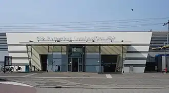 bâtiment de gare précédé par une esplanade piétonne, avec un vélo