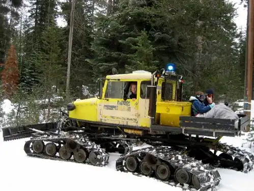 Chenilles à travers d'acier boulonnés sur courroies de caoutchouc renforcées.