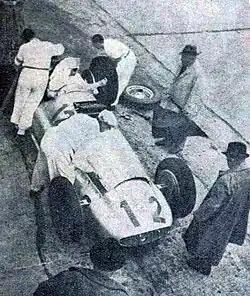 Photo en plongée de Rudolf Caracciola dans sa voiture pendant un ravitaillement.