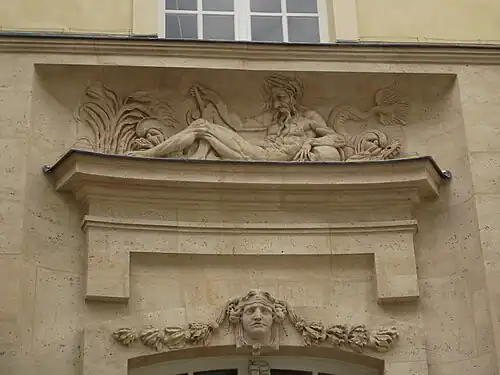 Bas-relief d'un « fleuve » et mascaron ornant la façade.