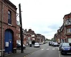 Rue Mattéotti : à gauche portail, vestige d'une ancienne ferme. Au-delà, la rue reconstruite dans les années 1950 a été élargie.