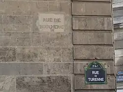 Ancien nom « rue Boucherat » gravé, et plaque avec le nouveau nom.