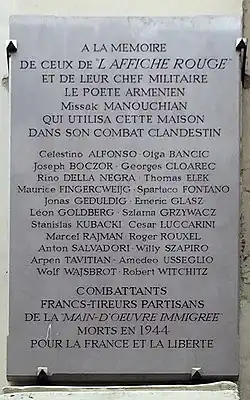 Photographie d'une plaque commémorative sur laquelle on peut lire « A la mémoire de ceux de l'Affiche rouge et de leur chef militaire le poète arménien Missak Manouchian qui utilisa cette maison dans son combat clandestin », suivi de la liste des 22 autres résistants exécutés, puis de « Combattants Francs-tireurs partisans de la Main d'œuvre immigrée morts en 1944 pour la France et la liberté ».
