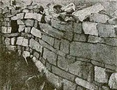Photographie en noir et blanc des vestiges d'un mur d'une église