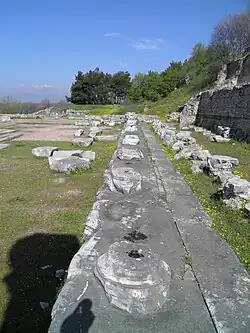 Enfilade de blocs gris supportant des bases de colonne