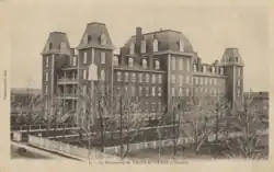 Photographie noir et blanc de l'immeuble d'une institution scolaire.