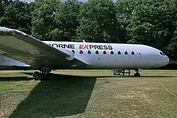 Caravelle exposée, parquée dans l'herbe, de profil. Peinture blanche.