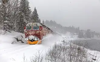 Un train de la compagnie SJ Norge&nbsp;(no) tracté par une locomotive Di 4 entre Finneidfjord et Mo i Rana pendant une tempete de neige. Mars 2022.