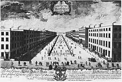 Gravure du 18 siècle montrant une vue en perspective d'une rue, bordée de maisons à étages, avec au centre une place bordée de murets surmontés de réverbères.