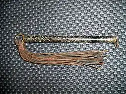 Bâton saihai avec des lanières de cuir.