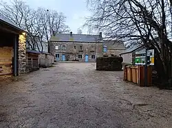 Photo de la cour d'une ferme avec les bâtiments.