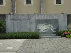 Une grande plaque noire, verticale, avec les noms des morts des guerres du XXIe&nbsp;siècle.