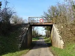 Le pont 34 de la ligne désaffectée enjambe une route communale.