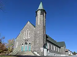 Une église en pierre, avec un clocher excentré.