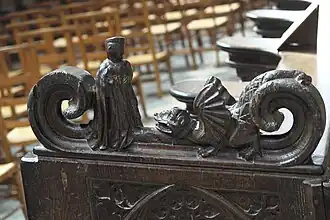 Photographie d'un accoudoir montrant une statue de Paul Aurélien face à un dragon.