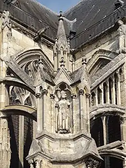 Culée d'arc-boutant avec, dans la niche, une statue d'homme très dégradée.