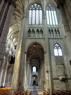 Mur de pierre avec, dans ses parties hautes, de grandes fenêtres. Au niveau intermédiaire, une galerie avec des arcades ajourées. Au niveau inférieur, une grande arcade est séparée d'un mur, sur lequel est incrusté une tourelle, par un pilier.