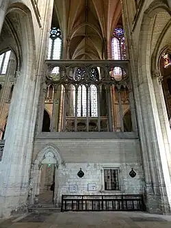 Mur massif en pierre surmonté d'arcades.