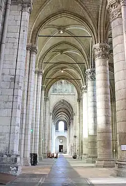 Bas-côté bordé de deux rangées de deux colonnes liés par des tirants de bois.