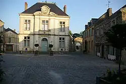 L'ancienne place du Pilori, emplacement des anciennes halles, la mairie (1884) et l'entrée du manoir de la Butte-Verte.