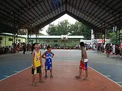 De jeunes joueurs de basket-ball sur un terrain aux Philippines.
