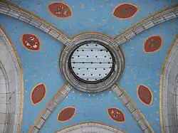 La voûte du porche est peinte d'un bleu ciel avec des étoiles dorées. Des fleurs (lys, rosiers) et des rameaux (olivier, lauriers) sont peints dans des mandorles