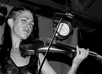 Photo en noir et blanc d'une femme jouant du violon.