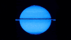 Saturne représentée bleue. Elle tourne sur elle-même et deux cercles brillants apparaissent aux pôles par intermittence.