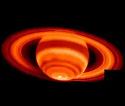 Image en nuances rouges de SAturne et de ses anneaux, le pôle sud est le point le plus clair de l'image.