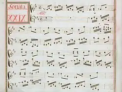 partition manuscrite rehaussée de couleurs passées rouge et vert en bordures et cadre de titre, titre en rouge