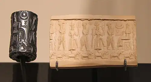 Sceau-cylindre avec impression, représentant trois adorants et deux dieux interposés, l'un portant un foudre, l'autre un trident, debout devant un dieu assis sur un trône. Cappadoce, Bronze moyen. Musée du Louvre.