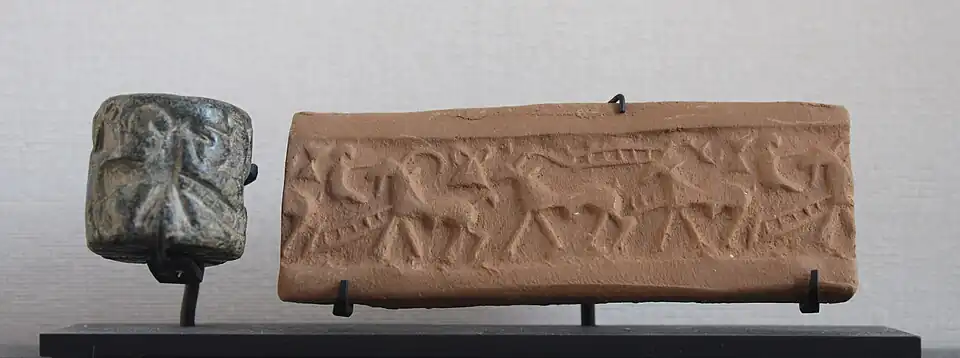 Sceau-cylindre en chlorite avec impression moderne, représentant un défilé de bêtes à cornes et d'autres motifs, notamment un petit personnage assis. Fin du IVe&nbsp;millénaire&nbsp;av. J.-C. Musée du Louvre.