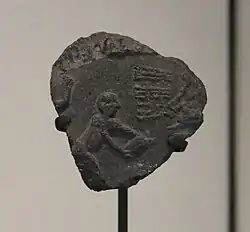 Bulle d'argile avec empreinte de scellement représentant une scène d'engrangement du grain, Suse II, Uruk récent. Musée du Louvre.