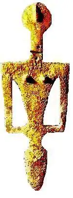 Statue jaune vif et ocre sur fond blanc, géométrique et bosselée.