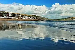 photo. Vue générale du port de Lyme Regis, au second plan, se reflétant dans la mer à marée descendante