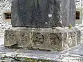 Saint-Ségal : le socle du calvaire de la chapelle Saint-Sébastien, masques.