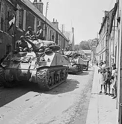 Chars M4 Sherman et Jeep du 30e corps d'armée britannique traversant Bayeux en 1944, pendant la bataille de Normandie.