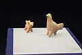 Figurines d’argile: un chien apportant un poisson (?) et une poule.