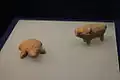 Figurines d’argile: une tortue et un porc.