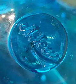 Signature d'Auguste Jean, AJean. Pastille de verre appliquée à chaud. Entre 1877 et 1884.