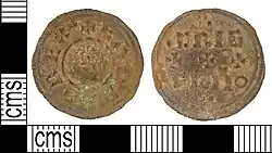 Photo des deux faces d'une pièce de monnaie corrodée portant des inscriptions en majuscules et de petites croix.