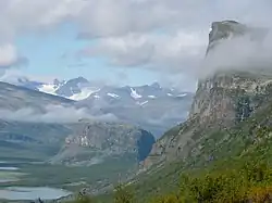 La montagne Skierffe légèrement entourée de nuages présente un à-pic très important.