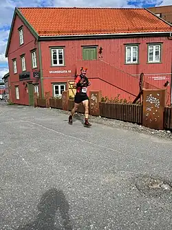 Traileur devant une maison rouge.