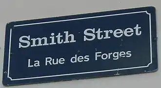 Plaque à lettres blanches sur fond bleu marine.
