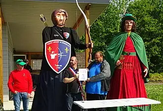 Rémy l'Archer (à gauche) et son parrain géant Jean le Messager dans sa deuxième version (à droite).