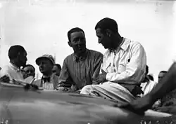 Photo de deux hommes en tenue de pilote discutant au milieu de la foule