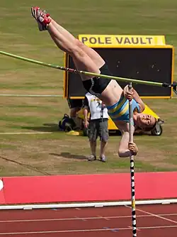 Photo d’une perchiste en train d’enrouler la barre.