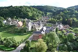 Photo du village de Sosoye montrant sa rue principale, l'église et laissant voir au premier plan la Molignée